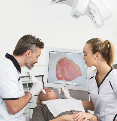 Dentist using a TRIOS® scanner on a patient in dental chair